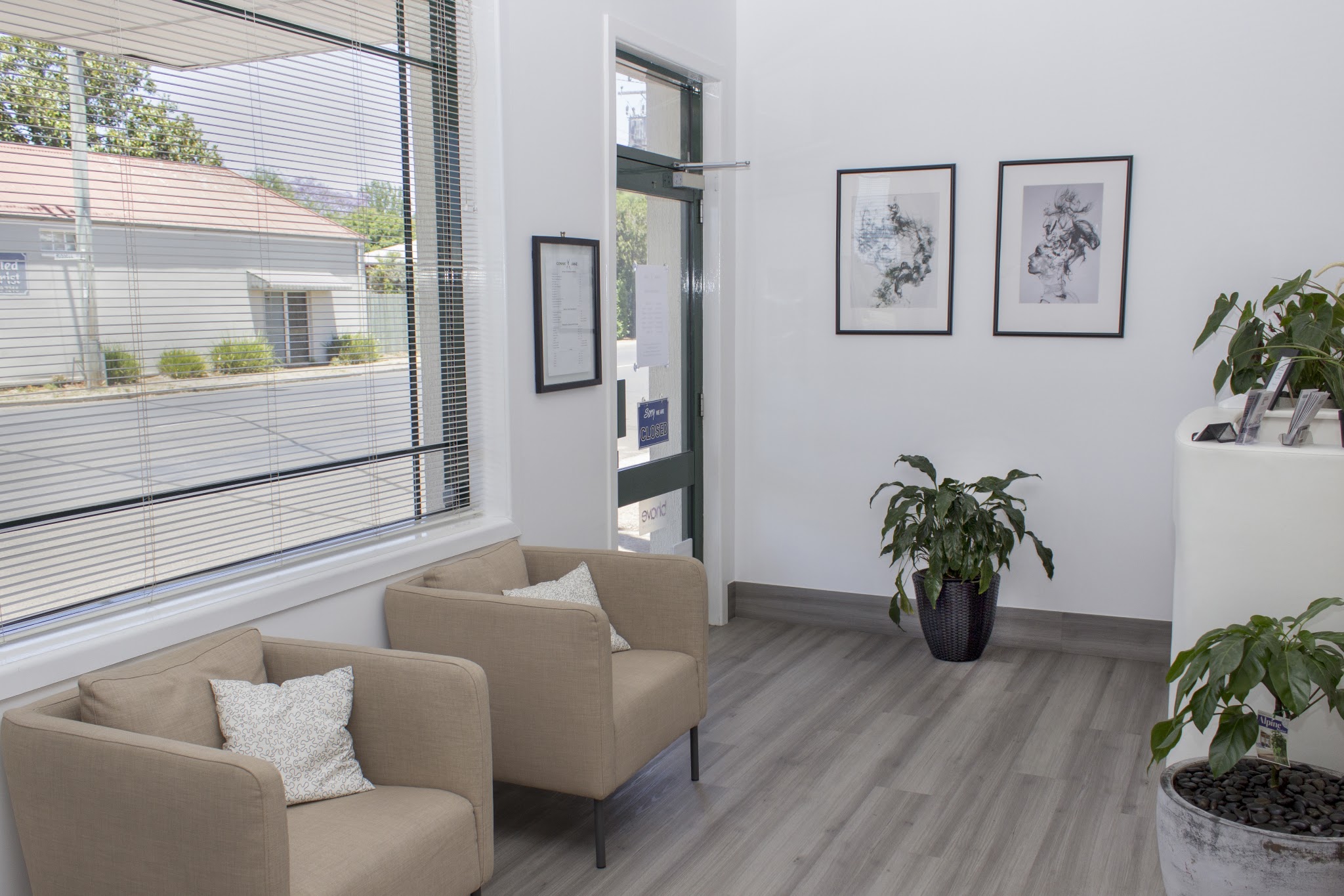 Waiting area with armchairs, framed prints and the street window
