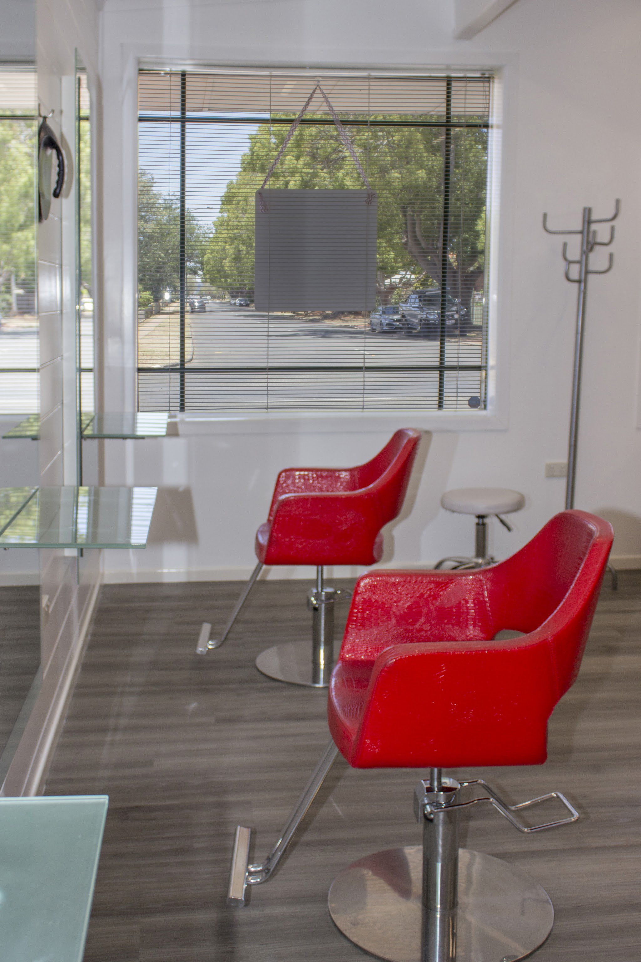 Two red styling chairs by the front window at Connie Janz Hair Studio